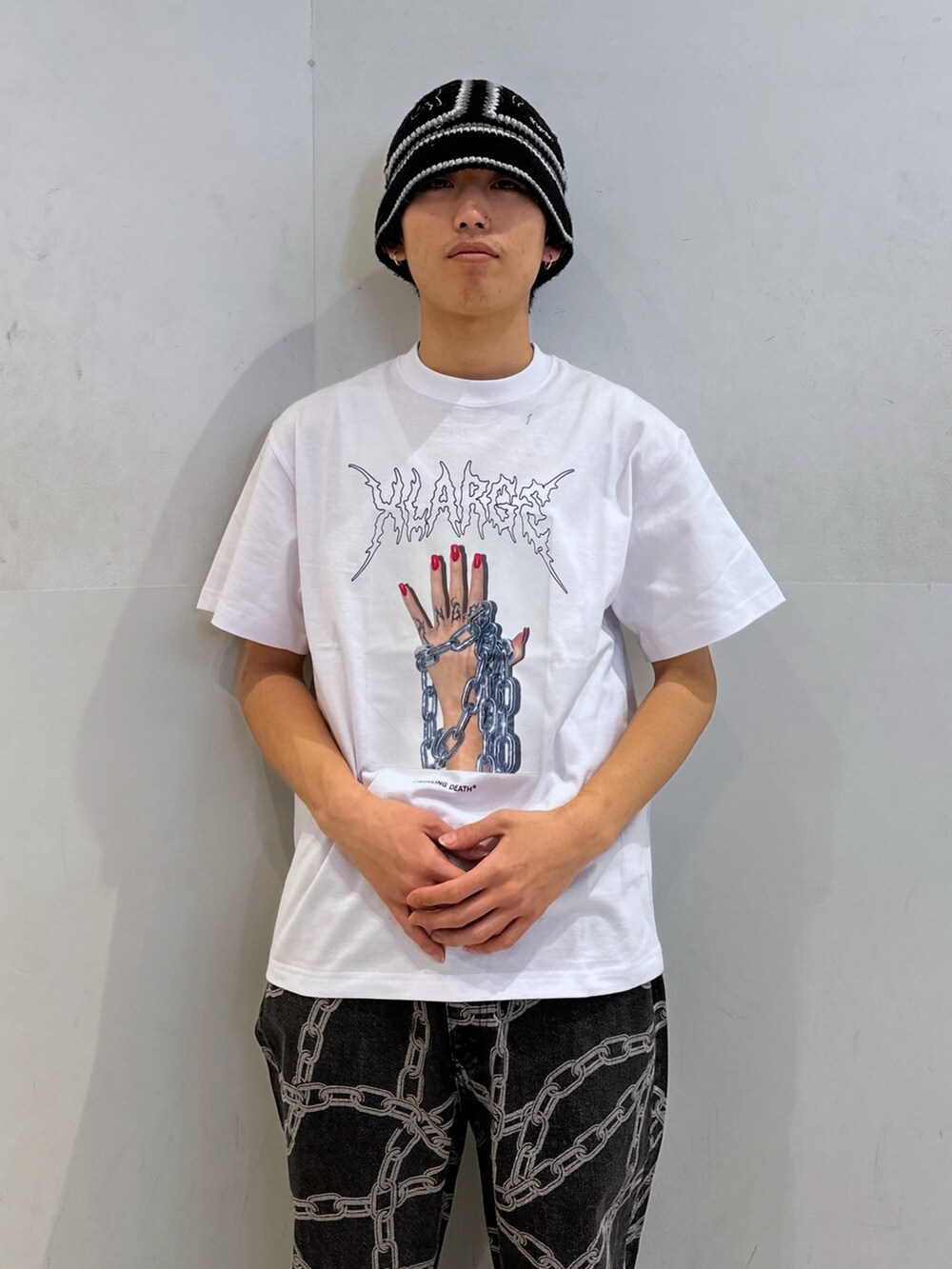 ホワイト系のTシャツ/カットソー、ブラック系のデニムパンツ、ブラック系のハットを着用したメンズの春コーディネートの5枚目の写真