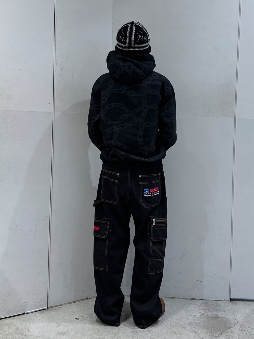 ブラック系のパーカー、ブラック系のデニムパンツ、ブラック系のハットを着用したメンズの春コーディネートの3枚目の写真