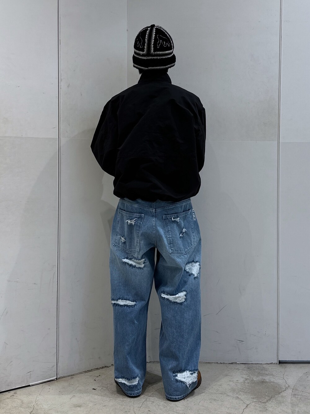 ブラック系のブルゾン、ブルー系のデニムパンツ、ブラック系のハットを着用したメンズの春コーディネートの3枚目の写真