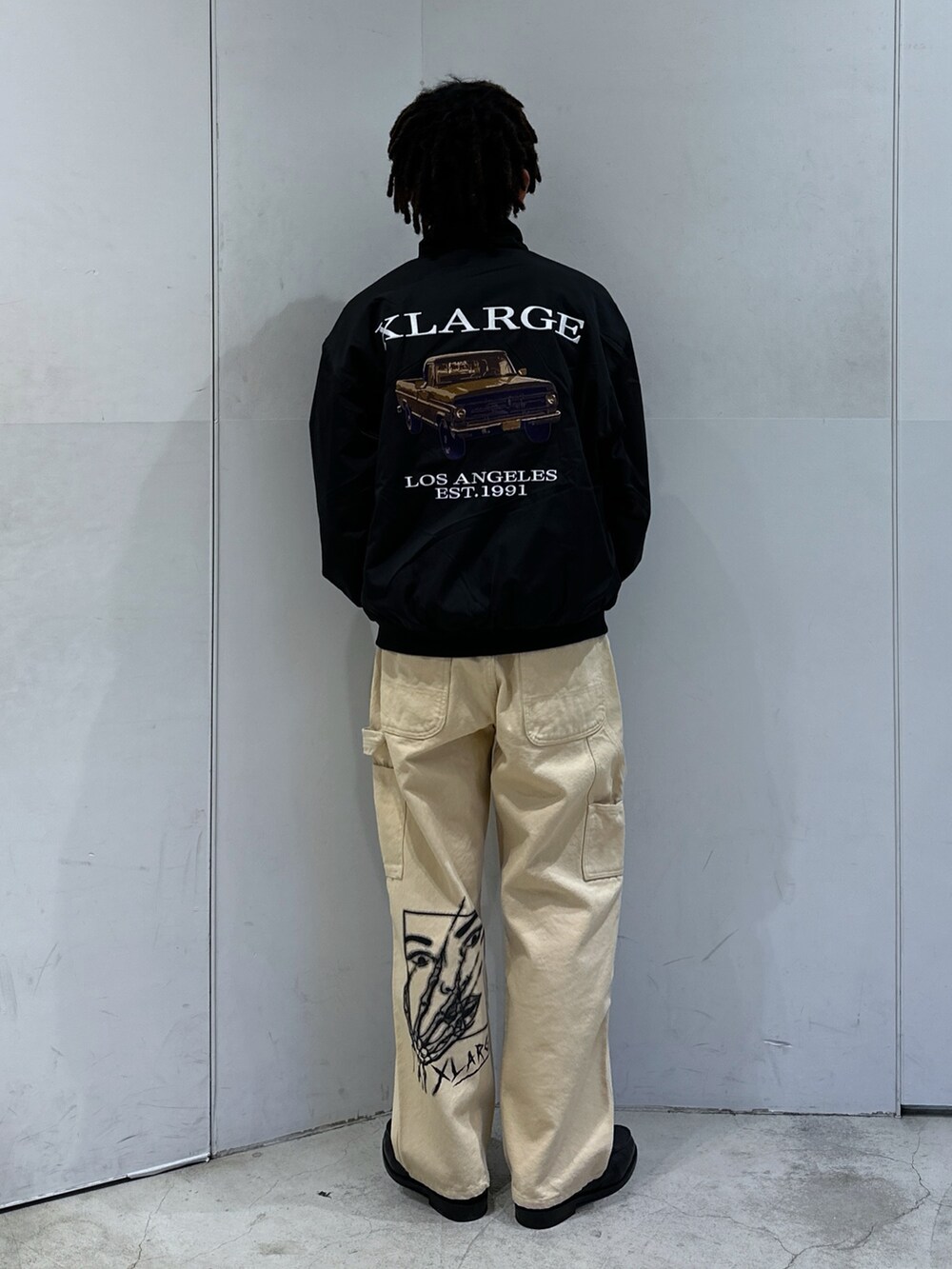 ブラック系のブルゾン、ベージュ系のその他パンツを着用したメンズの冬コーディネートの3枚目の写真