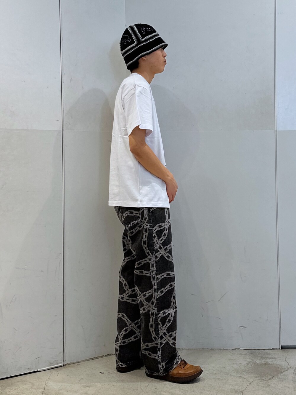 ホワイト系のTシャツ/カットソー、ブラック系のデニムパンツ、ブラック系のハットを着用したメンズの春コーディネートの4枚目の写真