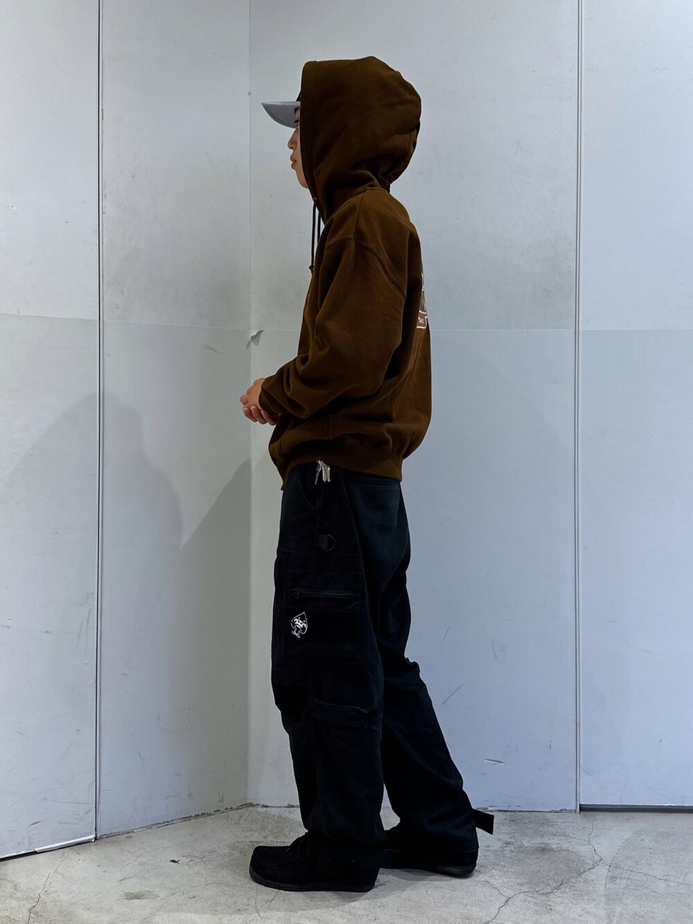 ブラウン系のパーカー、ブラック系のその他パンツ、ブラック系のキャップを着用したメンズの秋コーディネートの2枚目の写真