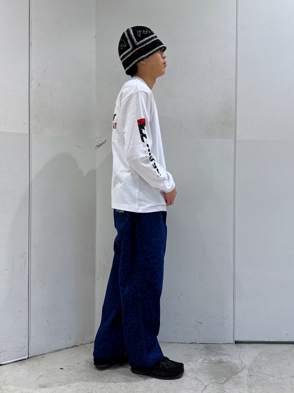 ホワイト系のTシャツ/カットソー、ブルー系のその他パンツ、ブラック系のハットを着用したメンズの冬コーディネートの4枚目の写真