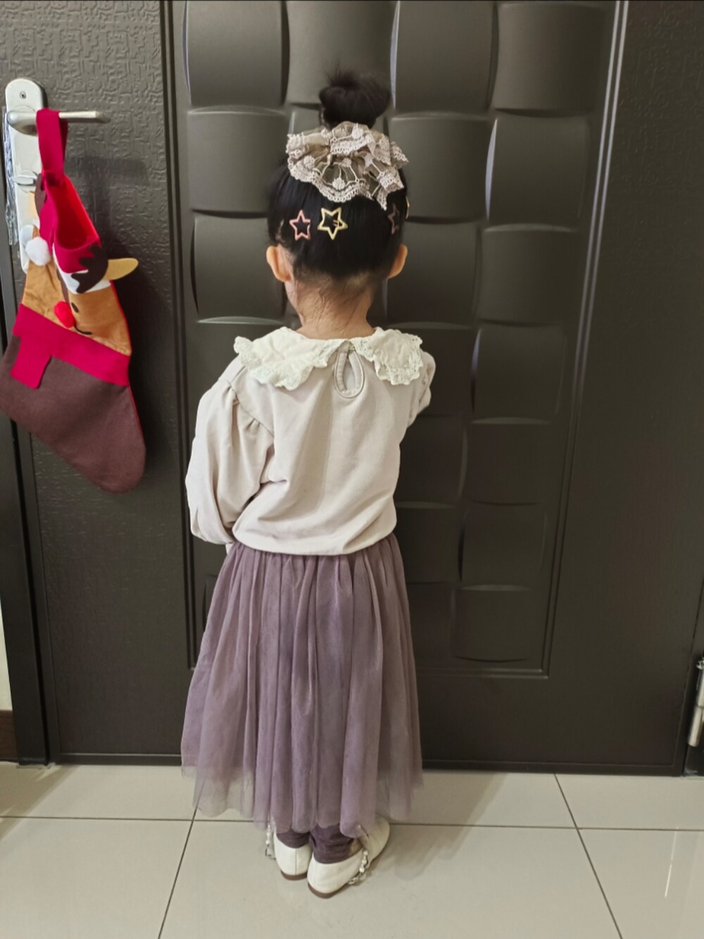 ベージュ系のその他トップス、パープル系のスカートを着用したキッズの冬コーディネートの2枚目の写真