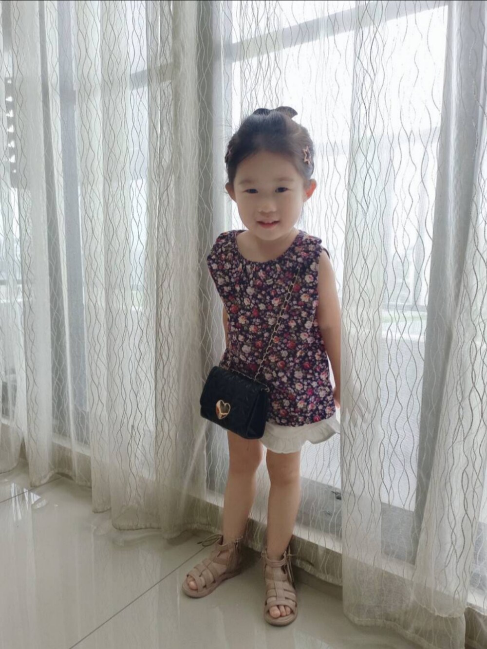 ブラック系のその他トップス、ホワイト系のカーゴパンツ、ピンク系のサンダルを着用したキッズの秋コーディネートの2枚目の写真