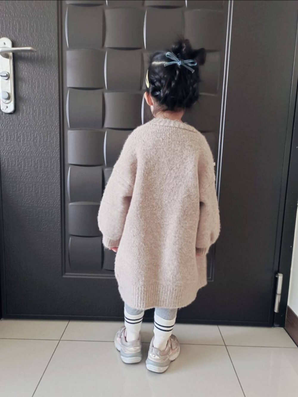 ブルー系のシャツワンピース、ピンク系のスニーカー、ベージュ系のノーカラージャケットを着用したキッズの冬コーディネートの2枚目の写真