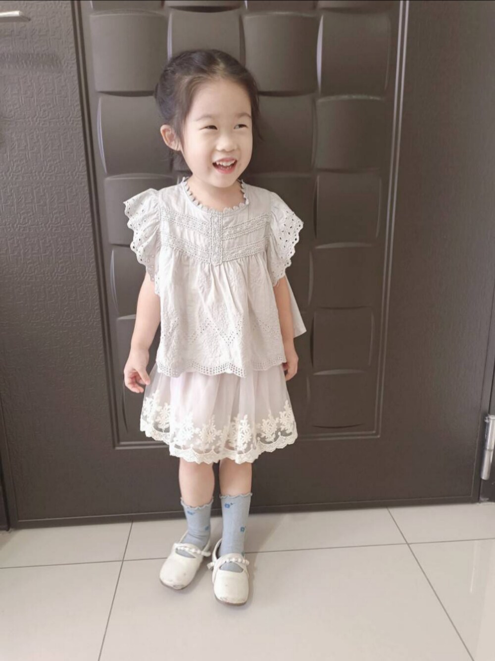 グレー系のその他トップス、グレー系のスカート、ホワイト系のバレエシューズを着用したキッズの秋コーディネートの2枚目の写真