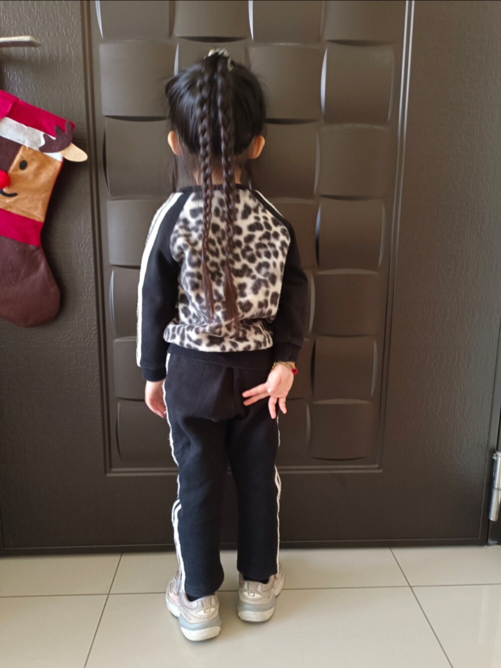 ブラック系のチノパンツ、ブラック系のジャージ、ピンク系のスニーカーを着用したキッズの冬コーディネートの2枚目の写真