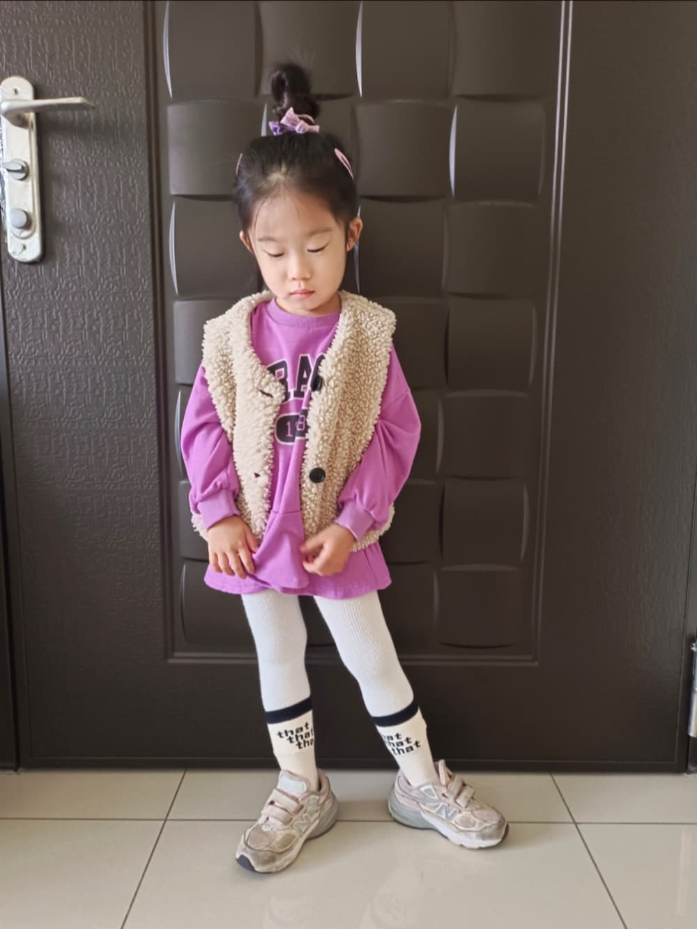 パープル系のTシャツ/カットソー、ベージュ系のその他アウター、ピンク系のスニーカーを着用したキッズの冬コーディネートの3枚目の写真