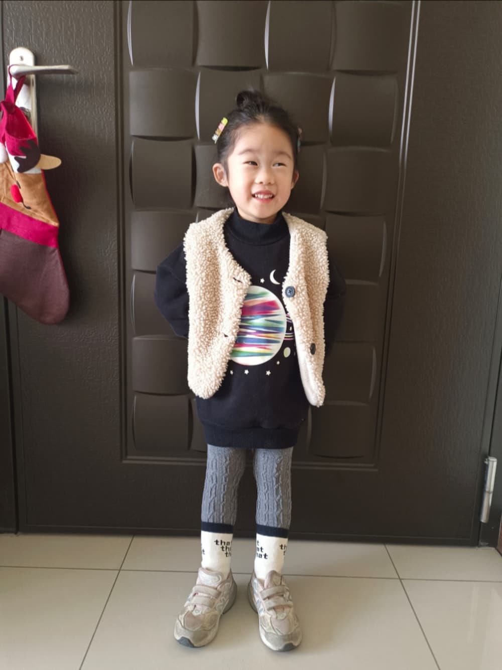 ブラック系のその他トップス、ベージュ系のダウンベスト、ピンク系のスニーカーを着用したキッズの冬コーディネートの2枚目の写真