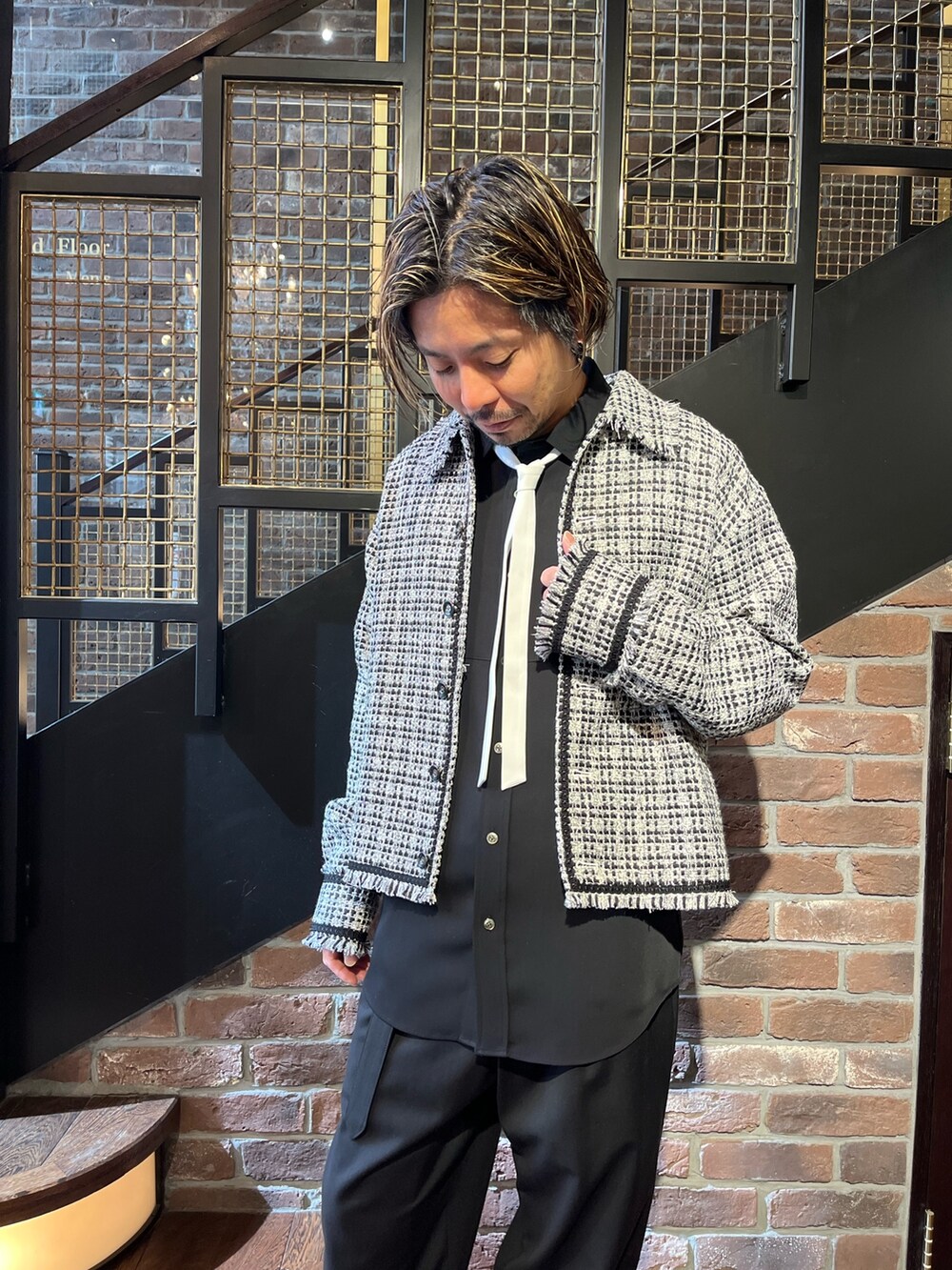 ホワイト系のブルゾン、ブラック系のシャツ/ブラウス、ブラック系のスラックスを着用したメンズの春コーディネートの2枚目の写真