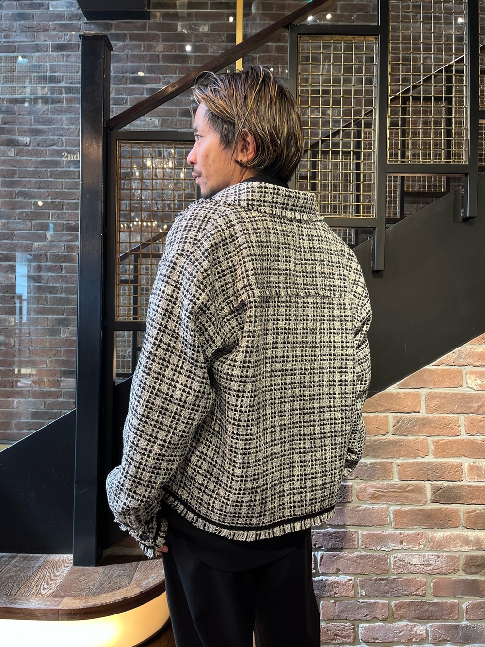 ホワイト系のブルゾン、ブラック系のシャツ/ブラウス、ブラック系のスラックスを着用したメンズの春コーディネートの3枚目の写真