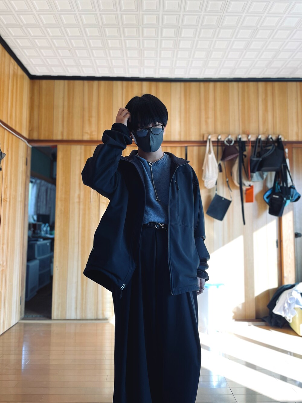 ブラック系のブルゾン、ブルー系のニット/セーター、ブラック系のスラックスを着用したメンズの冬コーディネートの2枚目の写真