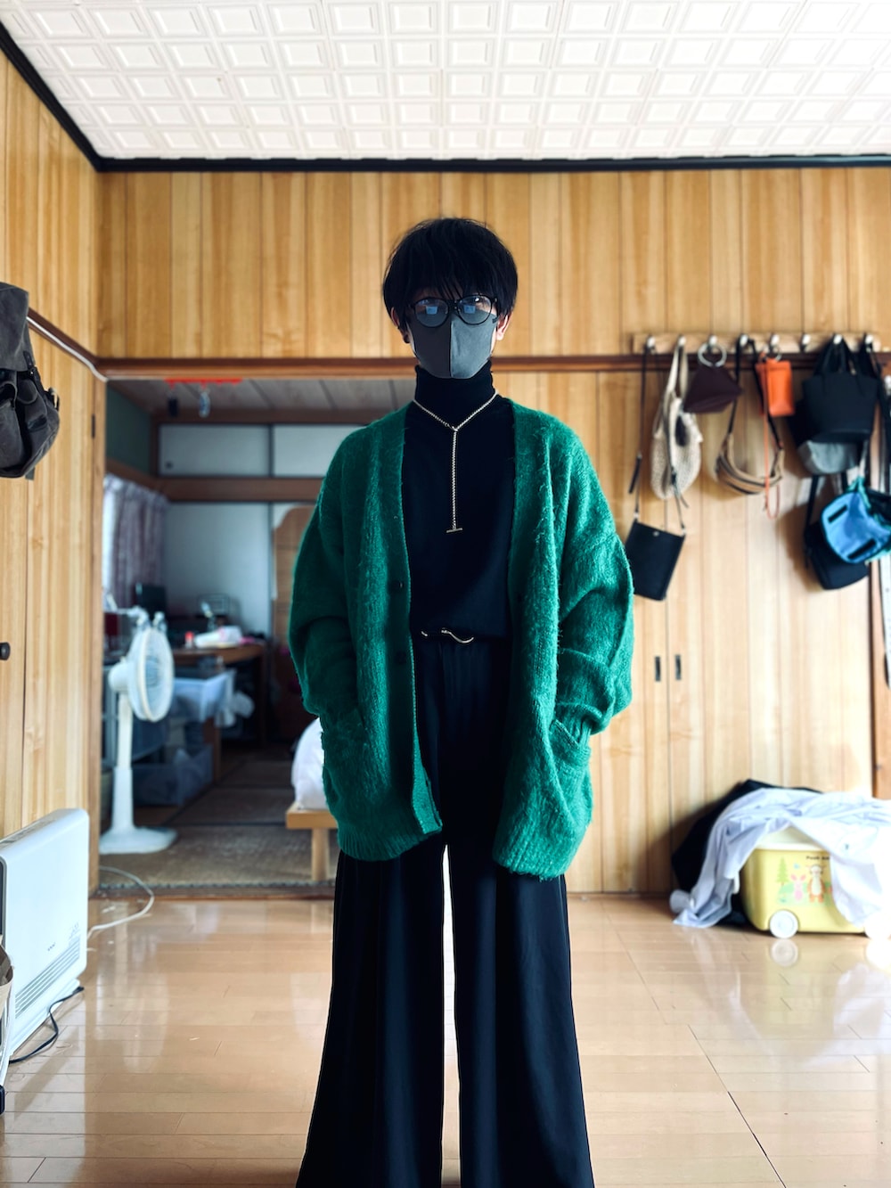 ブラック系のニット/セーター、グリーン系のカーディガン/ボレロ、ブラック系のスラックスを着用したメンズの秋コーディネートの2枚目の写真