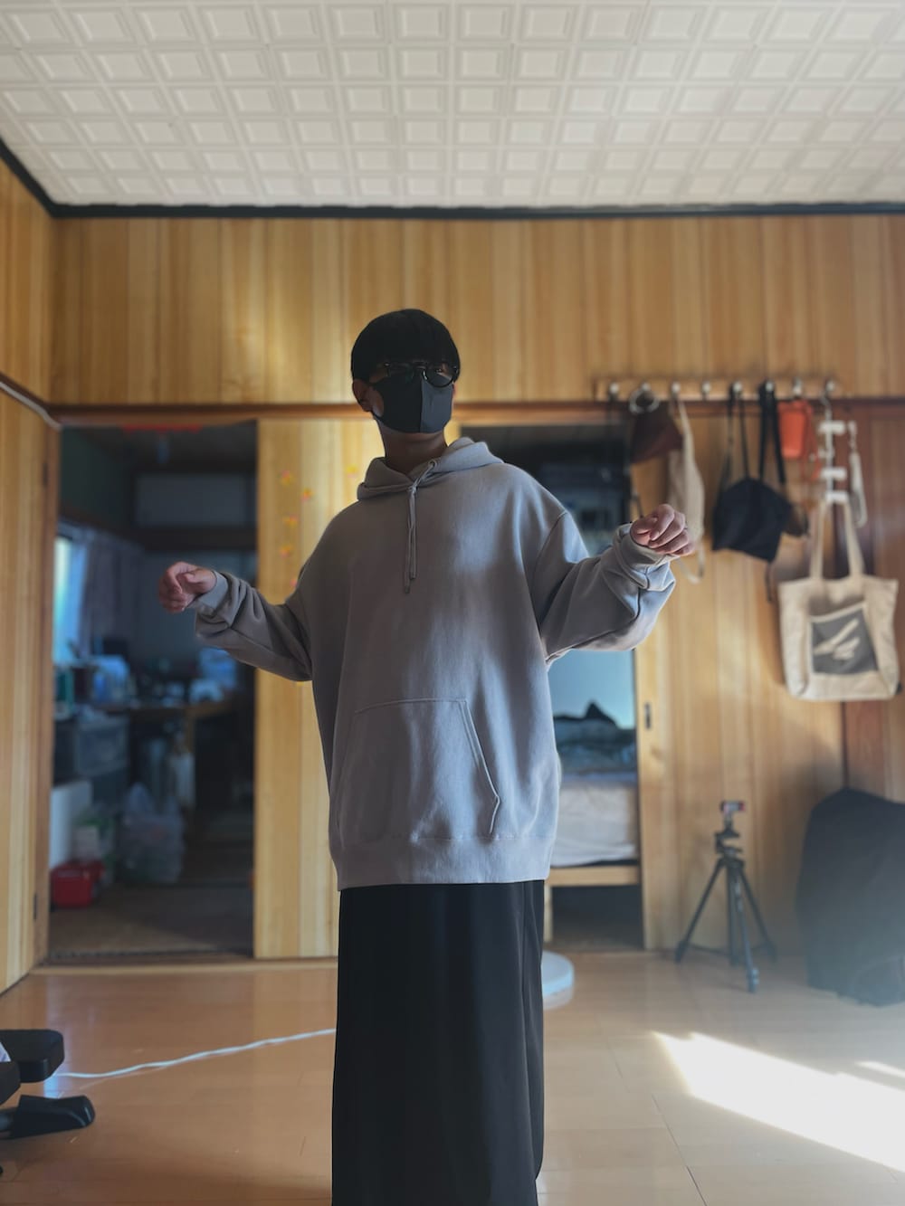 グレー系のパーカー、ブラック系のスラックス、レッド系のサングラスを着用したメンズの秋コーディネートの5枚目の写真