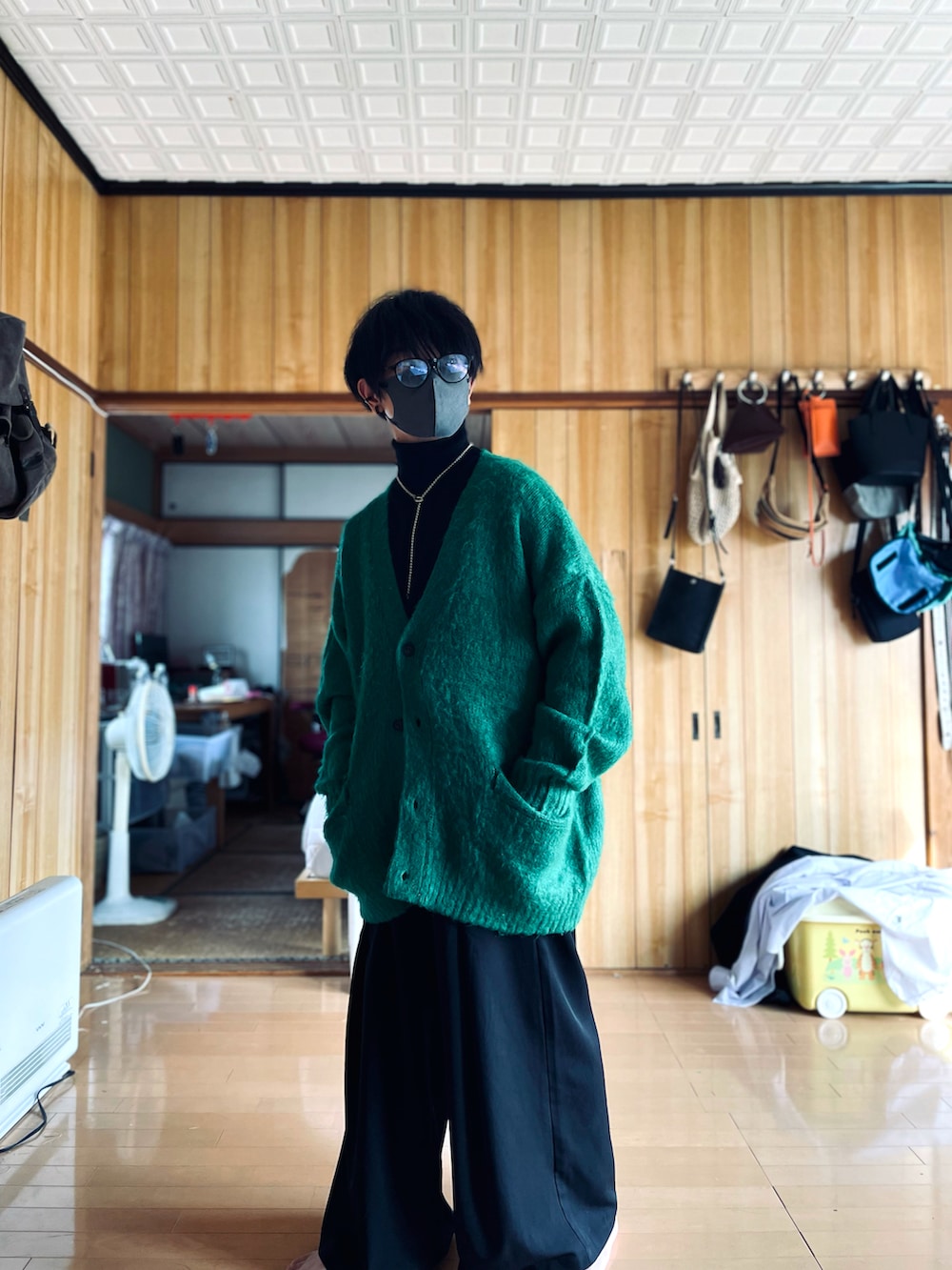 ブラック系のニット/セーター、グリーン系のカーディガン/ボレロ、ブラック系のスラックスを着用したメンズの秋コーディネートの5枚目の写真