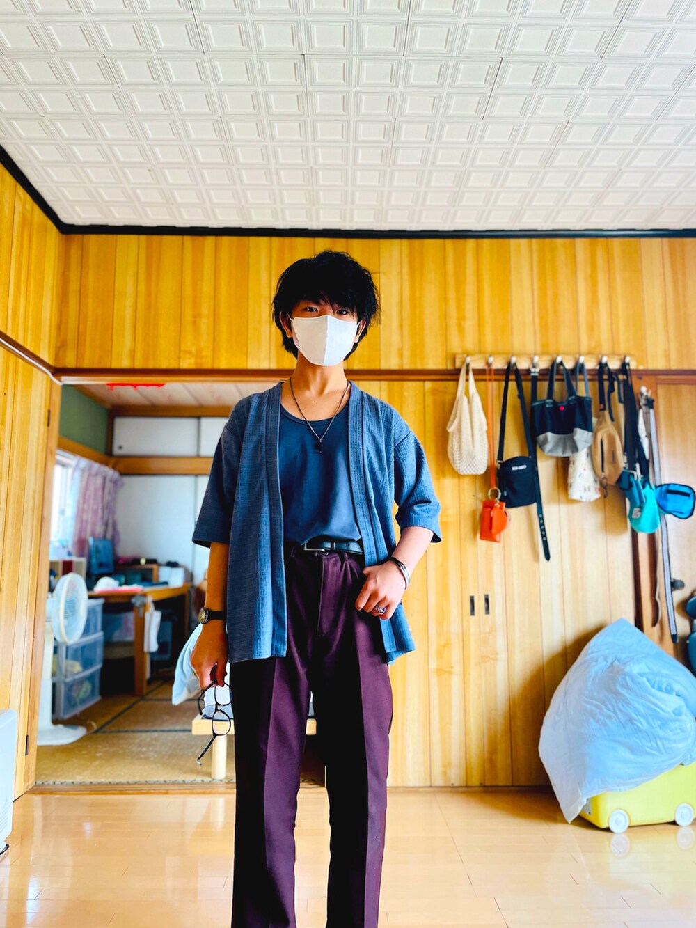 ブルー系のノーカラージャケット、ブルー系のタンクトップ、ブラウン系のスラックスを着用したメンズの夏コーディネートの4枚目の写真