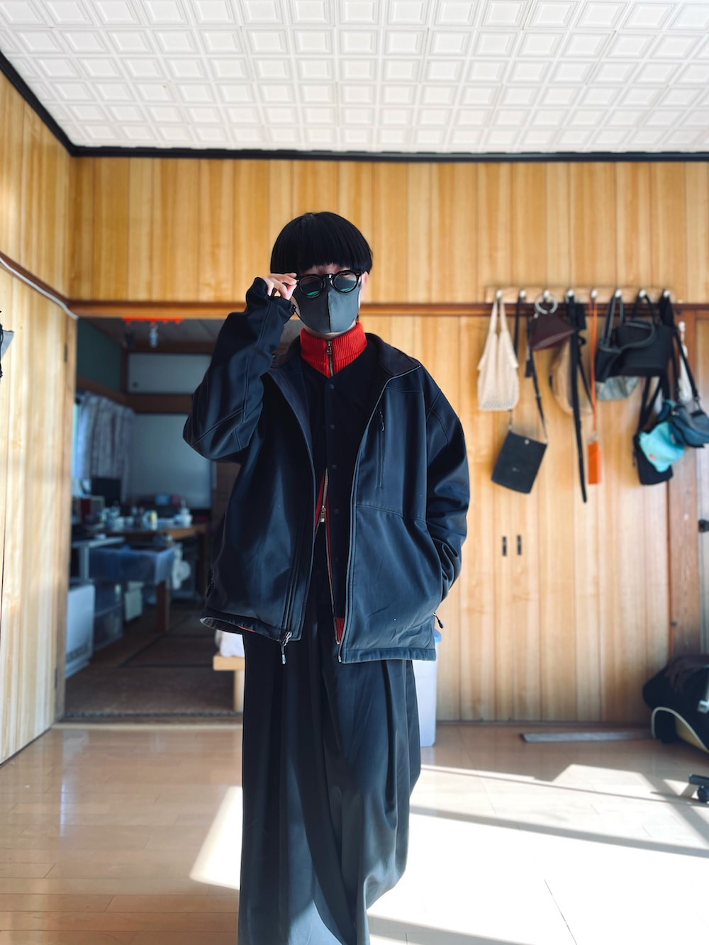 ブラック系のブルゾン、ブラック系のベスト、レッド系のカーディガン/ボレロを着用したメンズの冬コーディネートの2枚目の写真