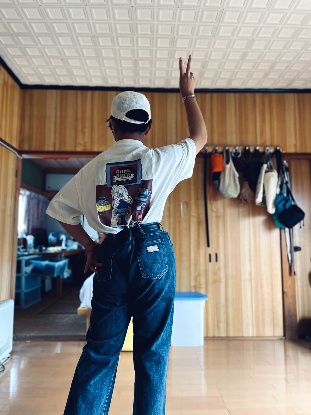 ホワイト系のTシャツ/カットソー、ブルー系のデニムパンツ、ブラック系のメガネを着用したメンズの秋コーディネートの4枚目の写真