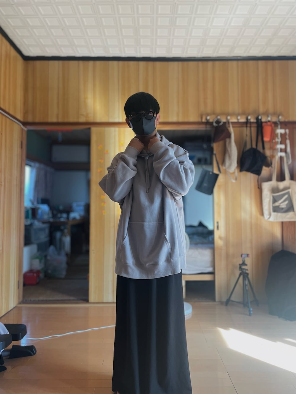 グレー系のパーカー、ブラック系のスラックス、レッド系のサングラスを着用したメンズの秋コーディネートの4枚目の写真