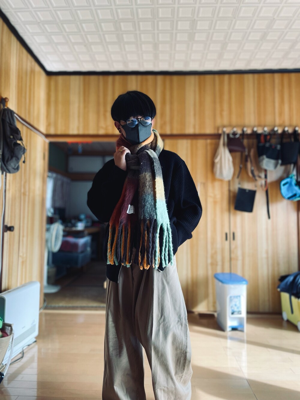 ブラック系のカーディガン/ボレロ、ベージュ系のその他パンツ、オレンジ系のマフラーを着用したメンズの秋コーディネートの2枚目の写真