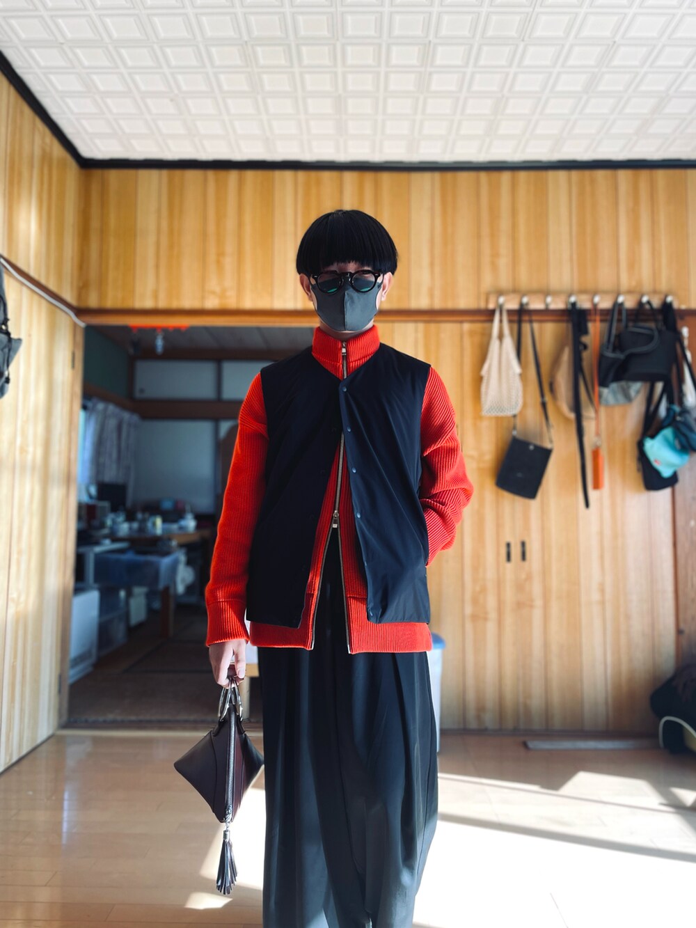 ブラック系のブルゾン、ブラック系のベスト、レッド系のカーディガン/ボレロを着用したメンズの冬コーディネートの3枚目の写真