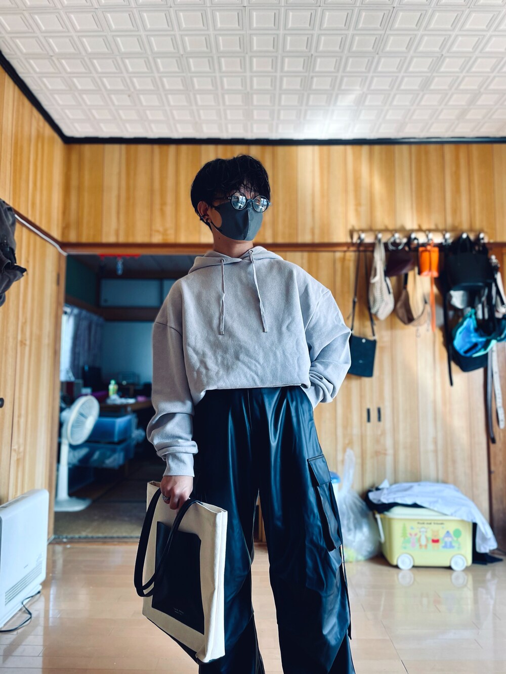 グレー系のパーカー、ブラック系のカーゴパンツ、ホワイト系のトートバッグを着用したメンズの秋コーディネートの2枚目の写真