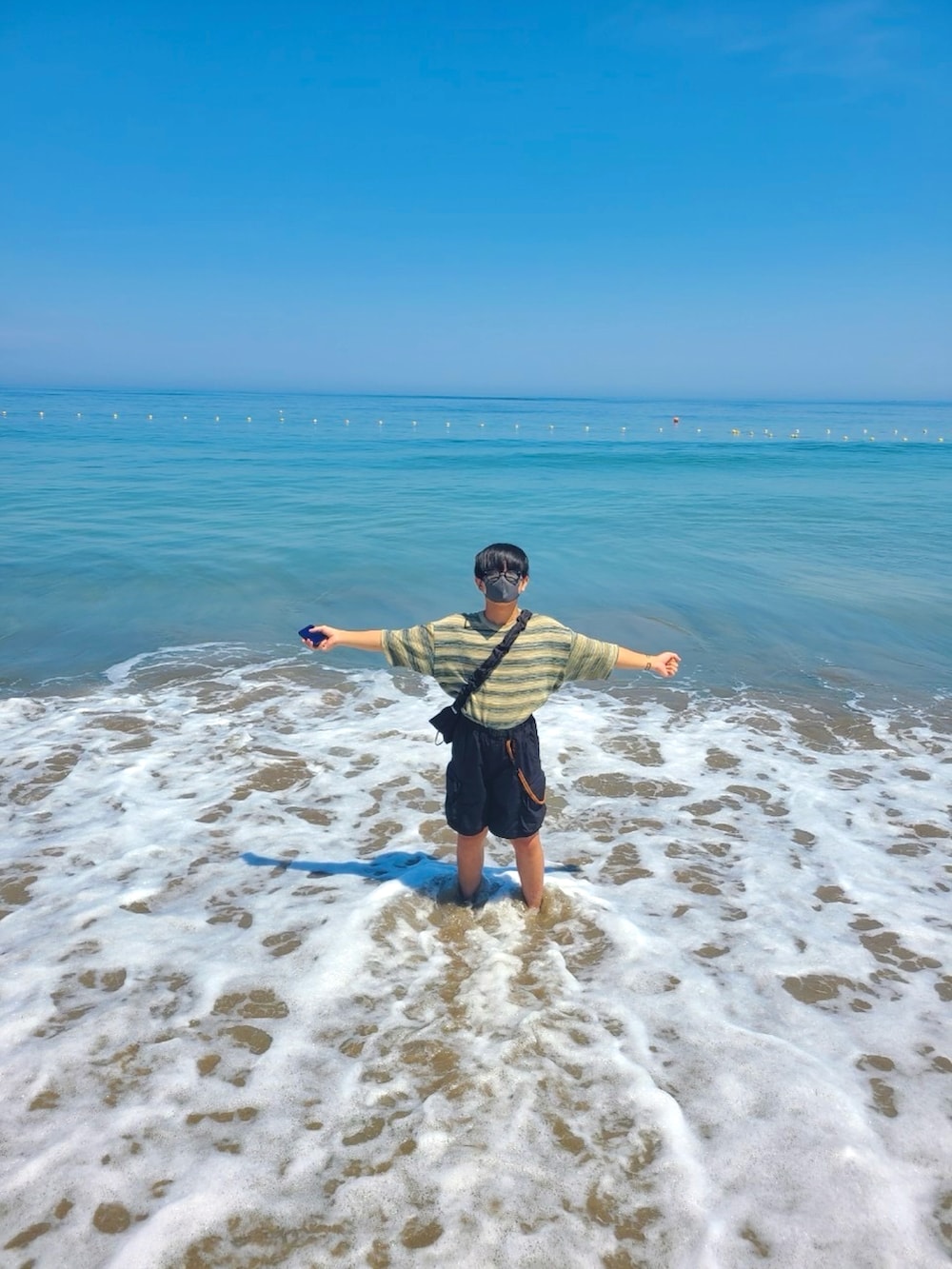 グリーン系のニット/セーター、ブラック系のその他パンツ、グレー系のサンダルを着用したメンズの夏コーディネートの3枚目の写真