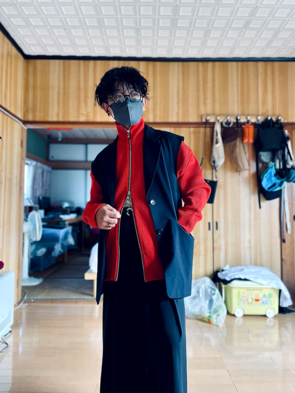 ブラック系のテーラードジャケット、レッド系のカーディガン/ボレロ、ブラック系のスラックスを着用したメンズの秋コーディネートの3枚目の写真