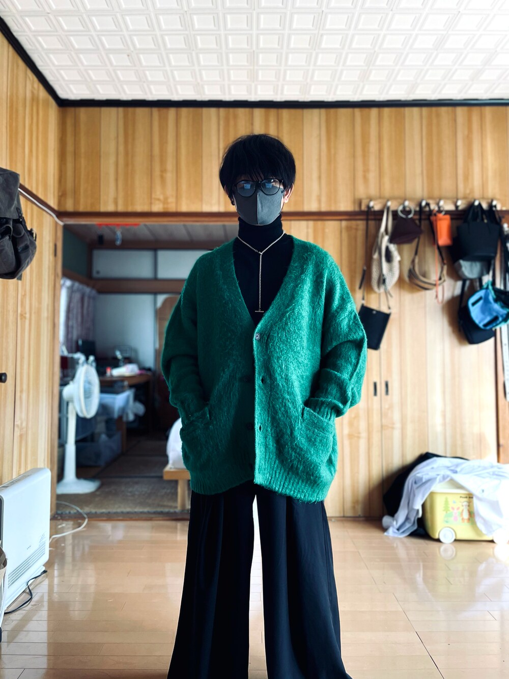 ブラック系のニット/セーター、グリーン系のカーディガン/ボレロ、ブラック系のスラックスを着用したメンズの秋コーディネートの4枚目の写真