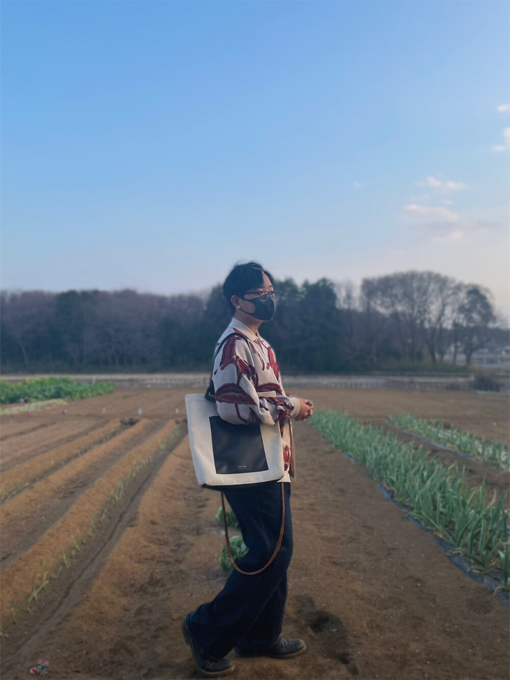 ホワイト系のカーディガン/ボレロ、ブルー系のデニムパンツ、ブラック系のブーツを着用したメンズの春コーディネートの5枚目の写真