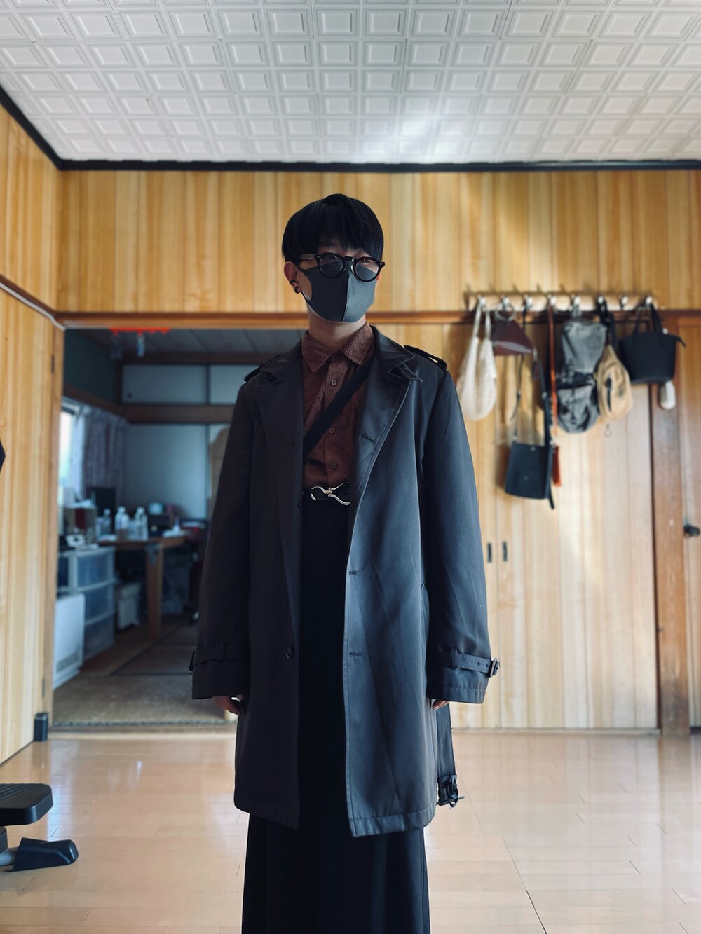 ブラウン系のシャツ/ブラウス、ブラウン系のチェスターコート、ブラック系のスラックスを着用したメンズの秋コーディネートの2枚目の写真