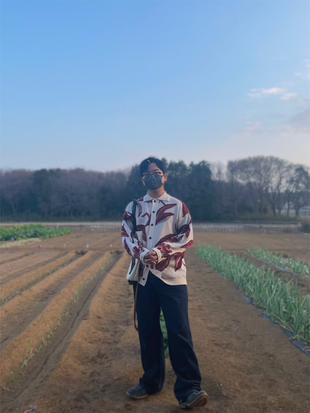 ホワイト系のカーディガン/ボレロ、ブルー系のデニムパンツ、ブラック系のブーツを着用したメンズの春コーディネートの3枚目の写真