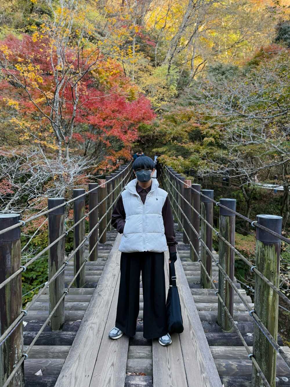 ホワイト系のダウンベスト、ブラウン系のシャツ/ブラウス、ブラック系のスラックスを着用したメンズの秋コーディネートの4枚目の写真