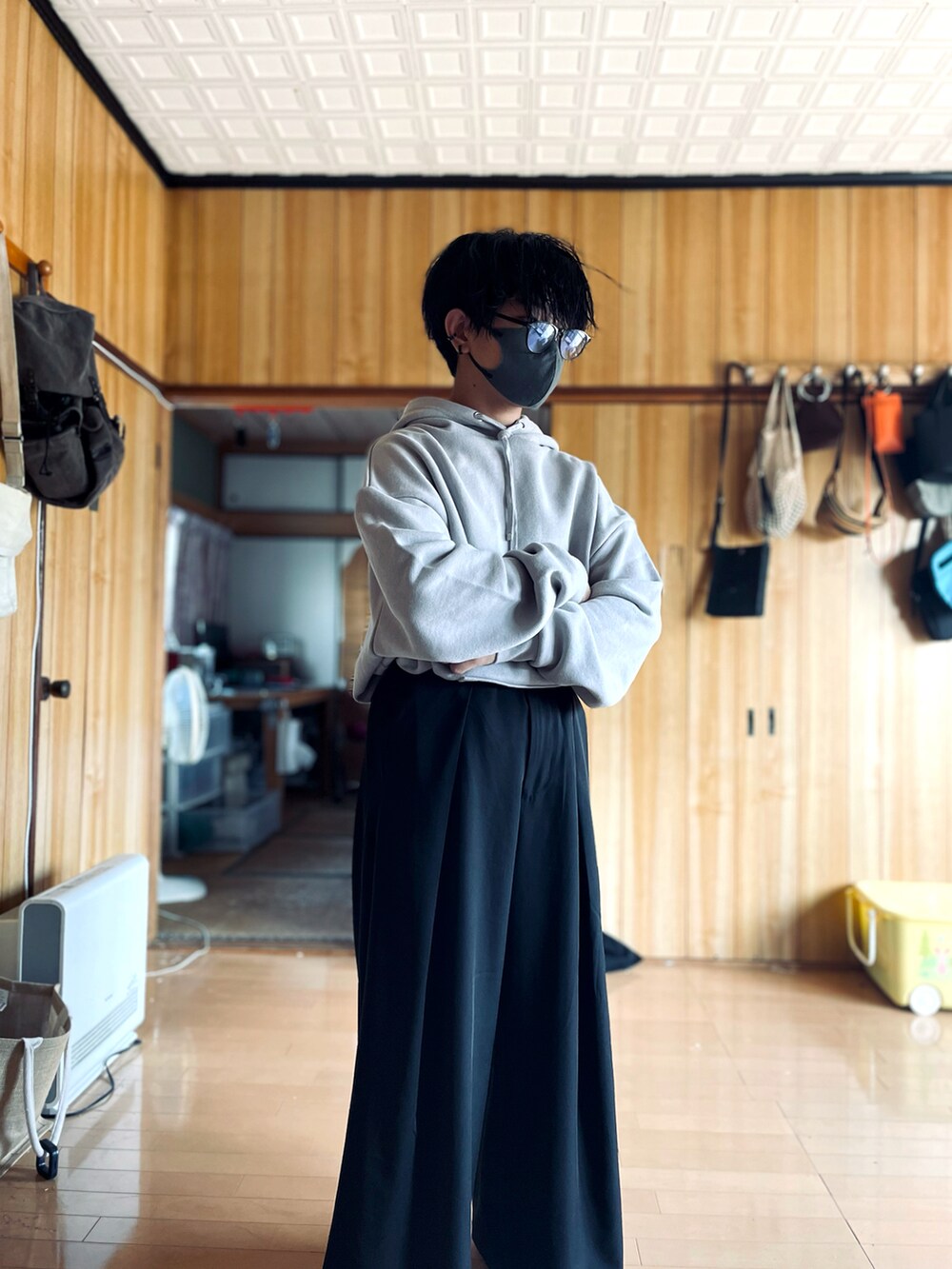 グレー系のパーカー、ブラック系のスラックス、ブラック系のメガネを着用したメンズの秋コーディネートの3枚目の写真