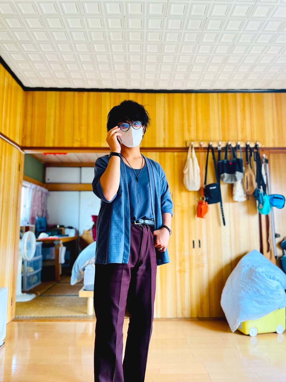 ブルー系のノーカラージャケット、ブルー系のタンクトップ、ブラウン系のスラックスを着用したメンズの夏コーディネートの2枚目の写真