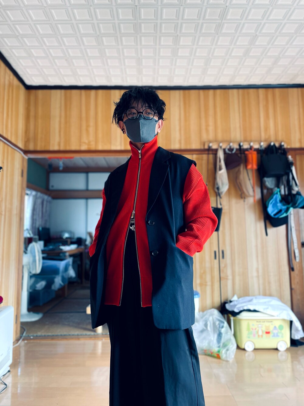 ブラック系のテーラードジャケット、レッド系のカーディガン/ボレロ、ブラック系のスラックスを着用したメンズの秋コーディネートの2枚目の写真