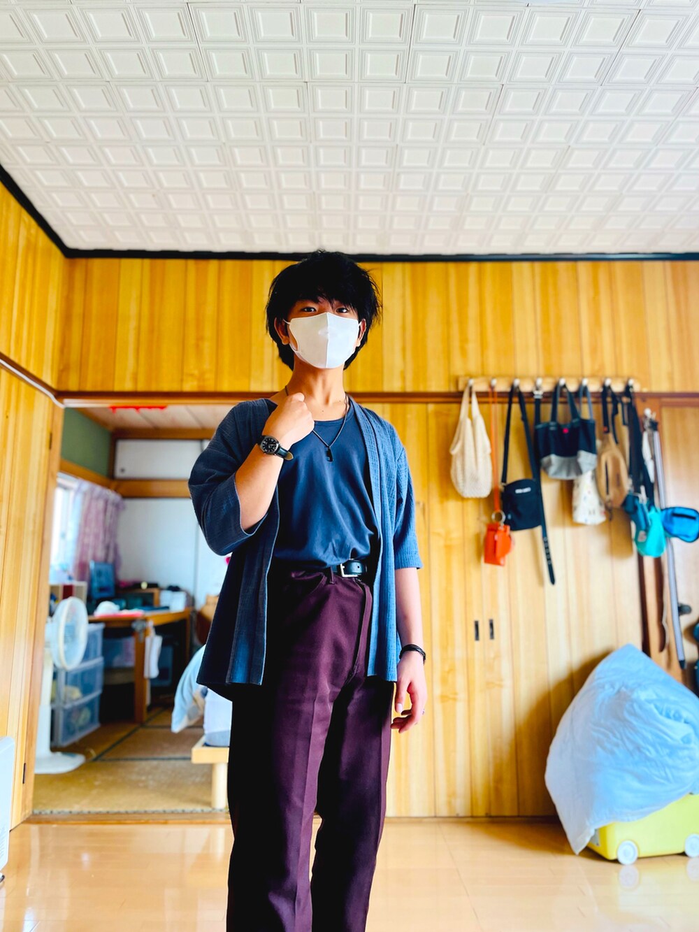 ブルー系のノーカラージャケット、ブルー系のタンクトップ、ブラウン系のスラックスを着用したメンズの夏コーディネートの3枚目の写真