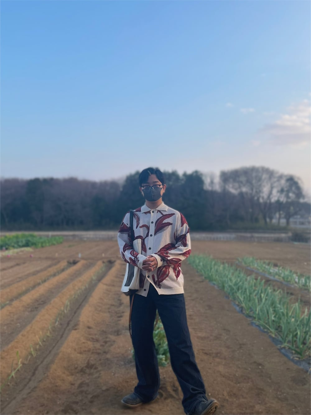 ホワイト系のカーディガン/ボレロ、ブルー系のデニムパンツ、ブラック系のブーツを着用したメンズの春コーディネートの2枚目の写真