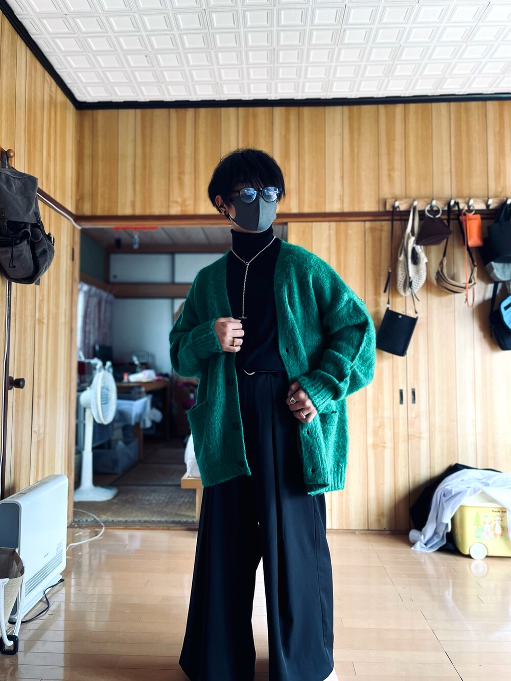 ブラック系のニット/セーター、グリーン系のカーディガン/ボレロ、ブラック系のスラックスを着用したメンズの秋コーディネートの3枚目の写真