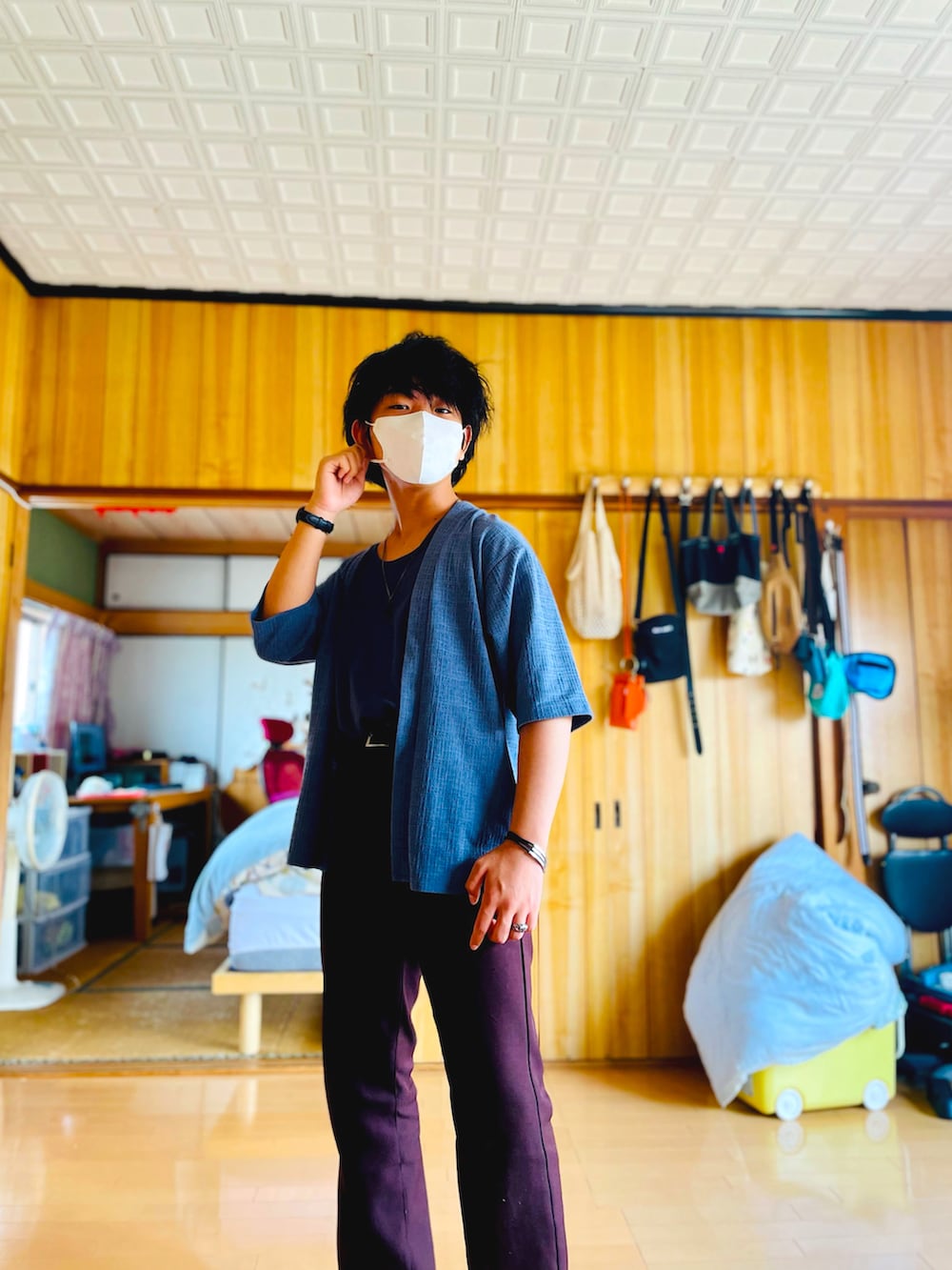 ブルー系のノーカラージャケット、ブルー系のタンクトップ、ブラウン系のスラックスを着用したメンズの夏コーディネートの5枚目の写真