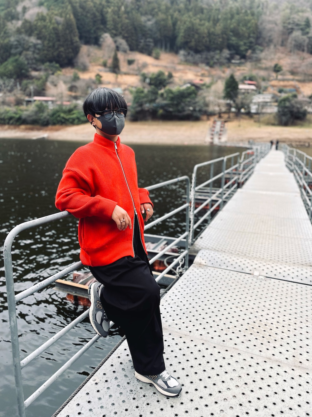 ブラック系のダウンジャケット/コート、レッド系のカーディガン/ボレロ、ブラック系のスラックスを着用したメンズの冬コーディネートの2枚目の写真