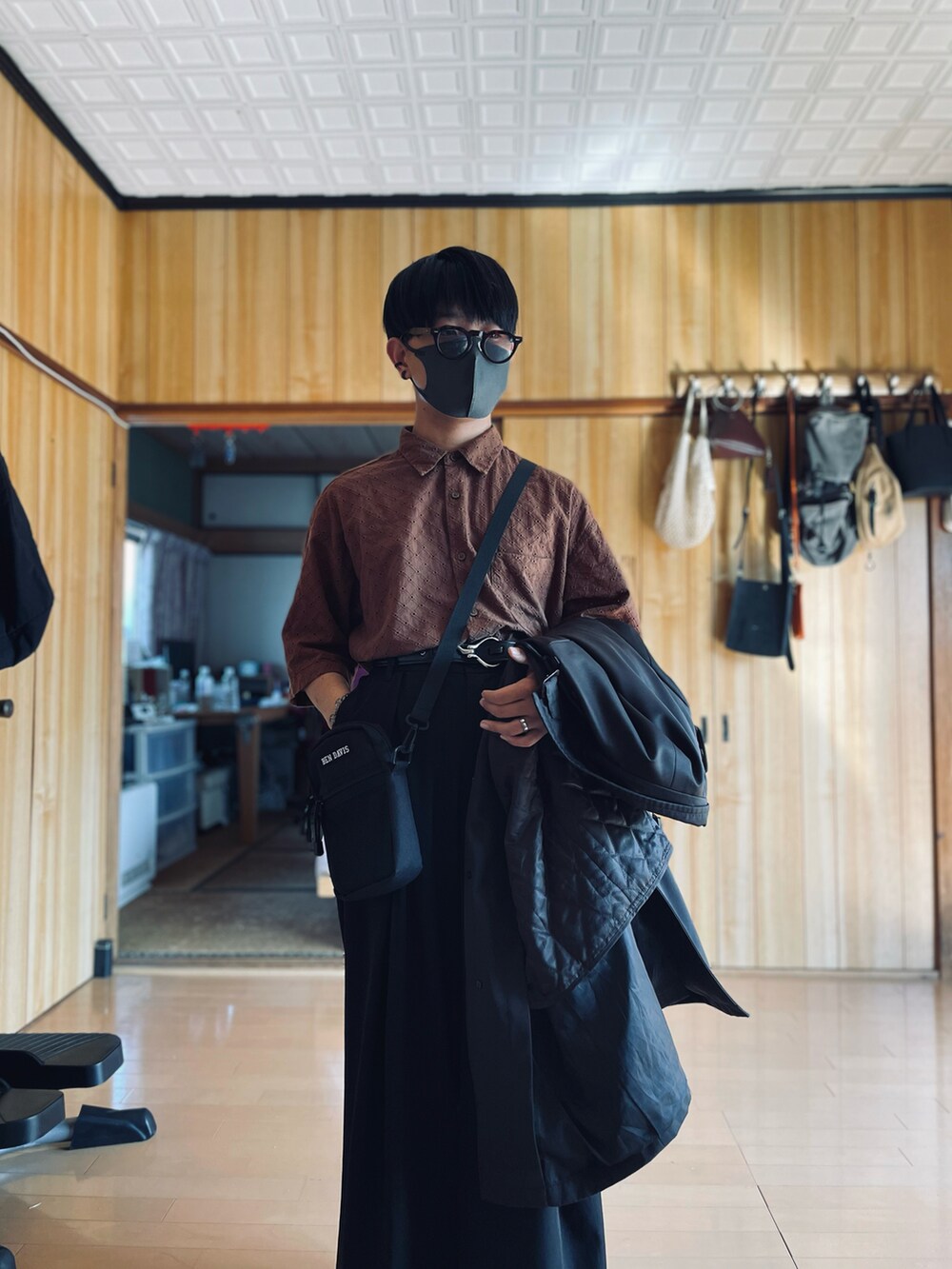 ブラウン系のシャツ/ブラウス、ブラウン系のチェスターコート、ブラック系のスラックスを着用したメンズの秋コーディネートの3枚目の写真