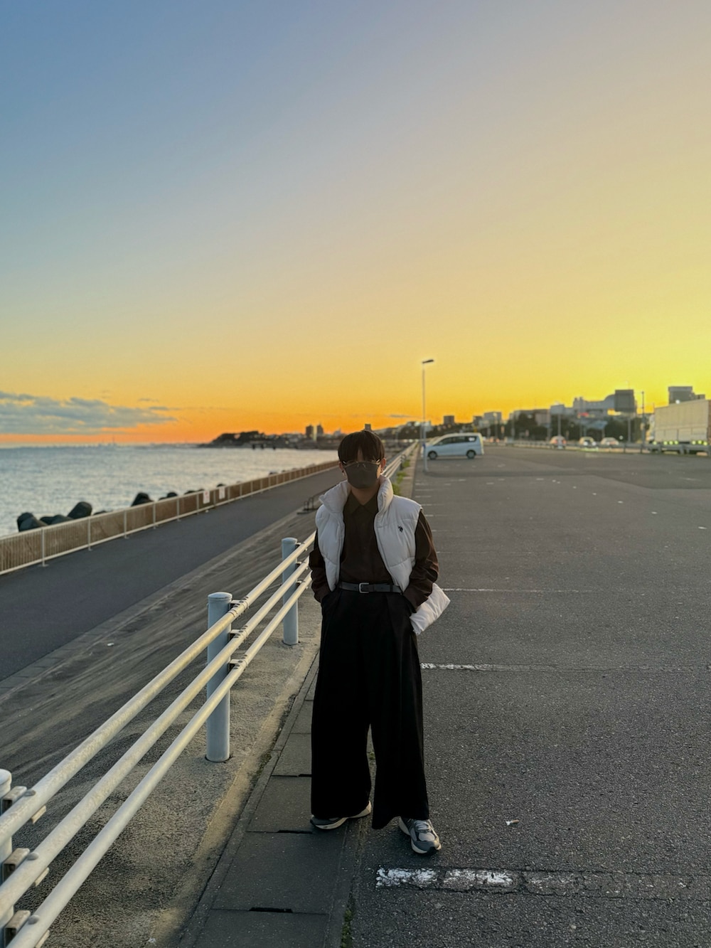 ホワイト系のダウンベスト、ブラウン系のシャツ/ブラウス、ブラック系のスラックスを着用したメンズの秋コーディネートの5枚目の写真