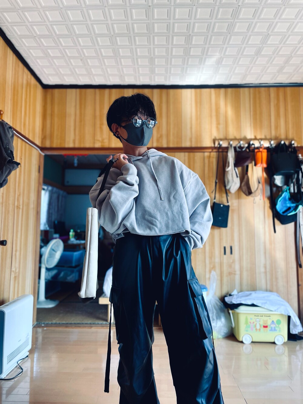 グレー系のパーカー、ブラック系のカーゴパンツ、ホワイト系のトートバッグを着用したメンズの秋コーディネートの3枚目の写真