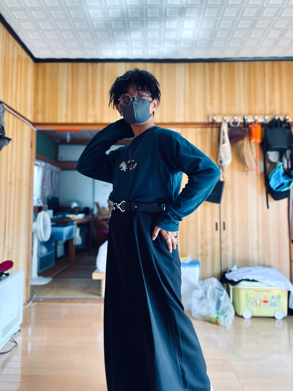 ブラック系のスラックス、グリーン系のTシャツ/カットソー、ブラック系のピアス（両耳用）を着用したメンズの秋コーディネートの2枚目の写真