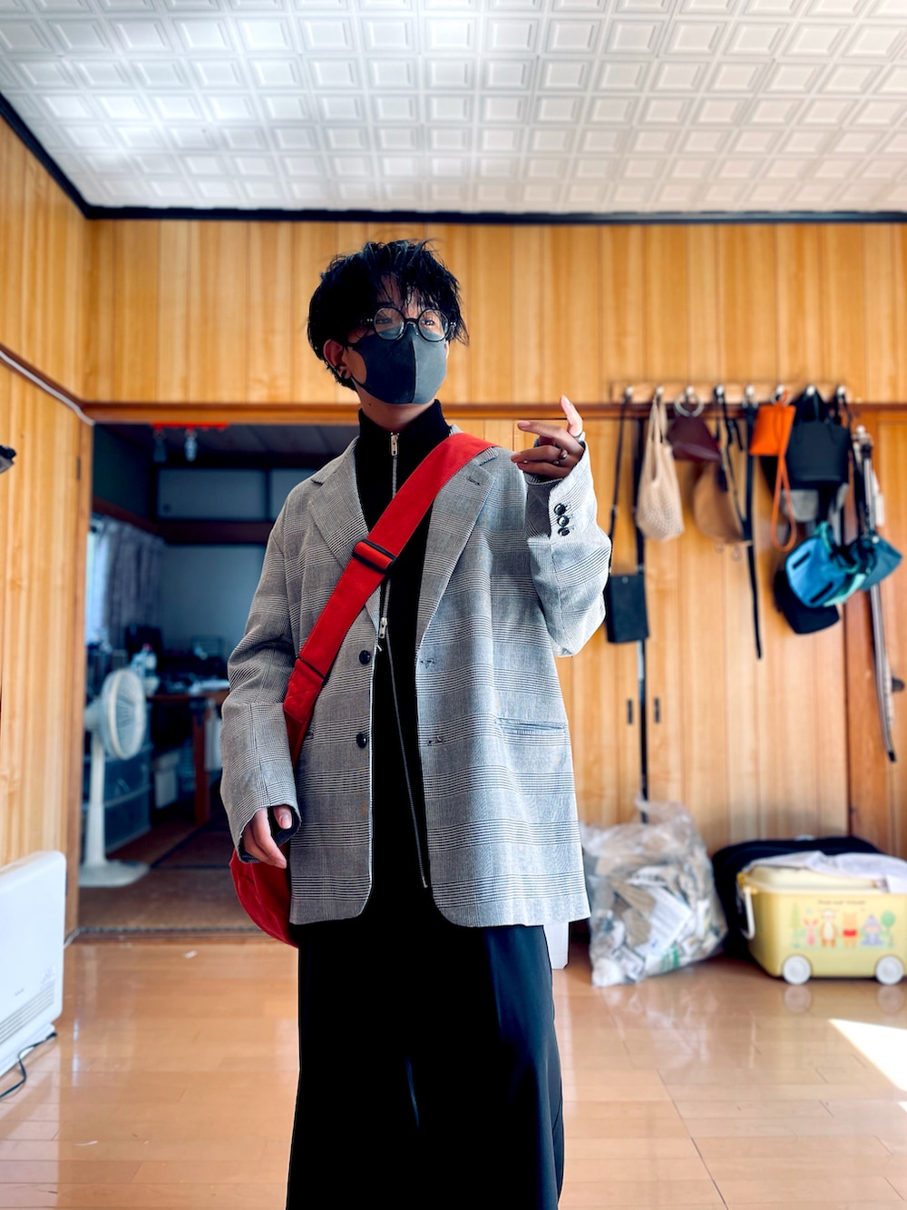 グレー系のテーラードジャケット、ブラック系のカーディガン/ボレロ、ブラック系のスラックスを着用したメンズの秋コーディネートの2枚目の写真