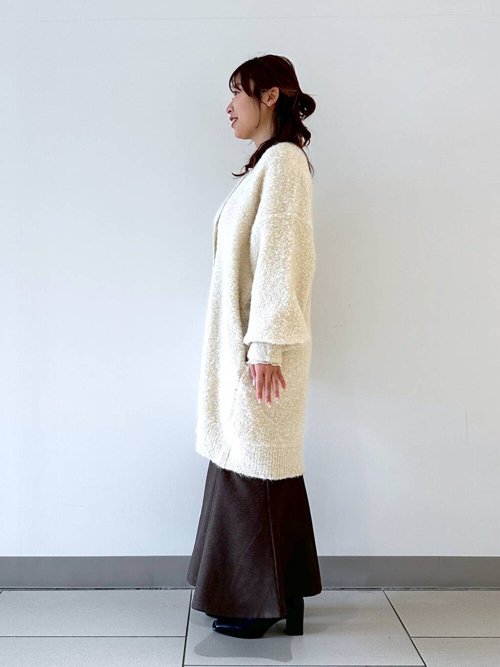 ホワイト系のTシャツ/カットソー、ホワイト系のチュニック、ブラウン系のスカートを着用したレディースの冬コーディネートの2枚目の写真