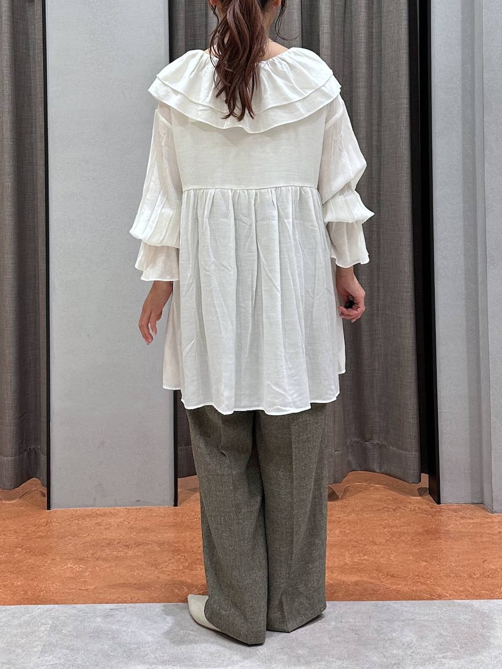 ゴールド系のタンクトップ、ホワイト系のパンプス、ブラウン系のデニムパンツを着用したレディースの春コーディネートの2枚目の写真