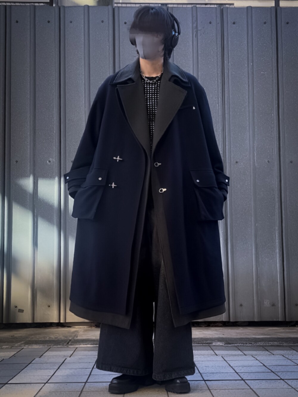 ブルー系のトレンチコート、ブラック系のデニムパンツ、ブラック系のニット/セーターを着用したメンズの冬コーディネートの2枚目の写真